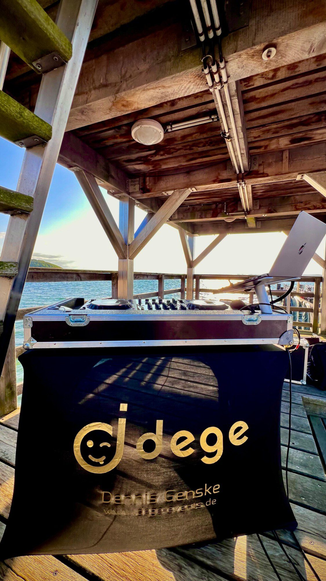 DJ-Pult auf einer Seebrücke an der Ostsee bei Sonnenuntergang